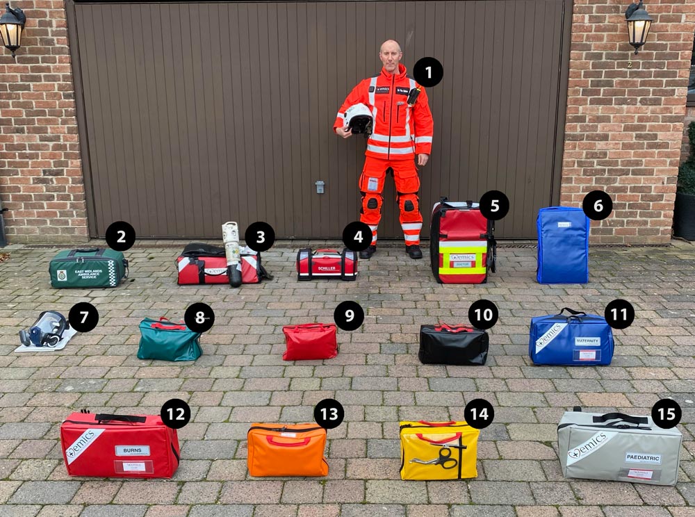 EMICS responder in full uniform with all 15 numbered equipment bags laid out on the driveway